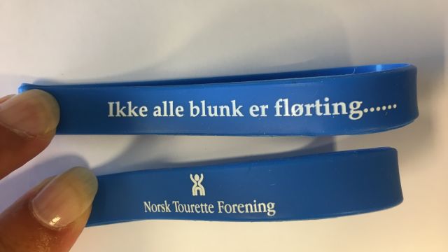 Bilde av armbånd med logo og teksten 