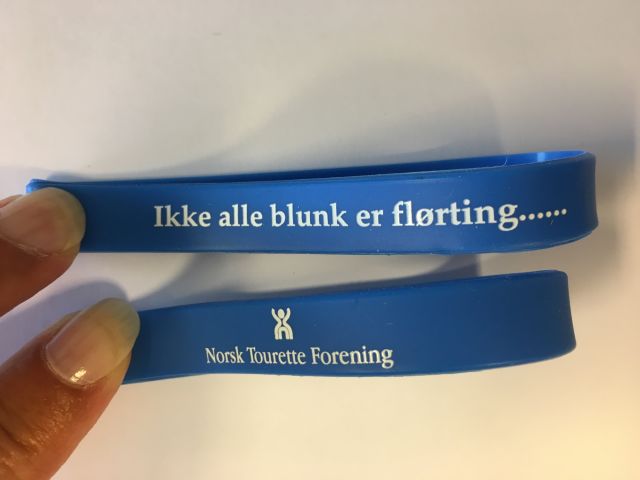 Bilde av armbånd med logo og teksten 